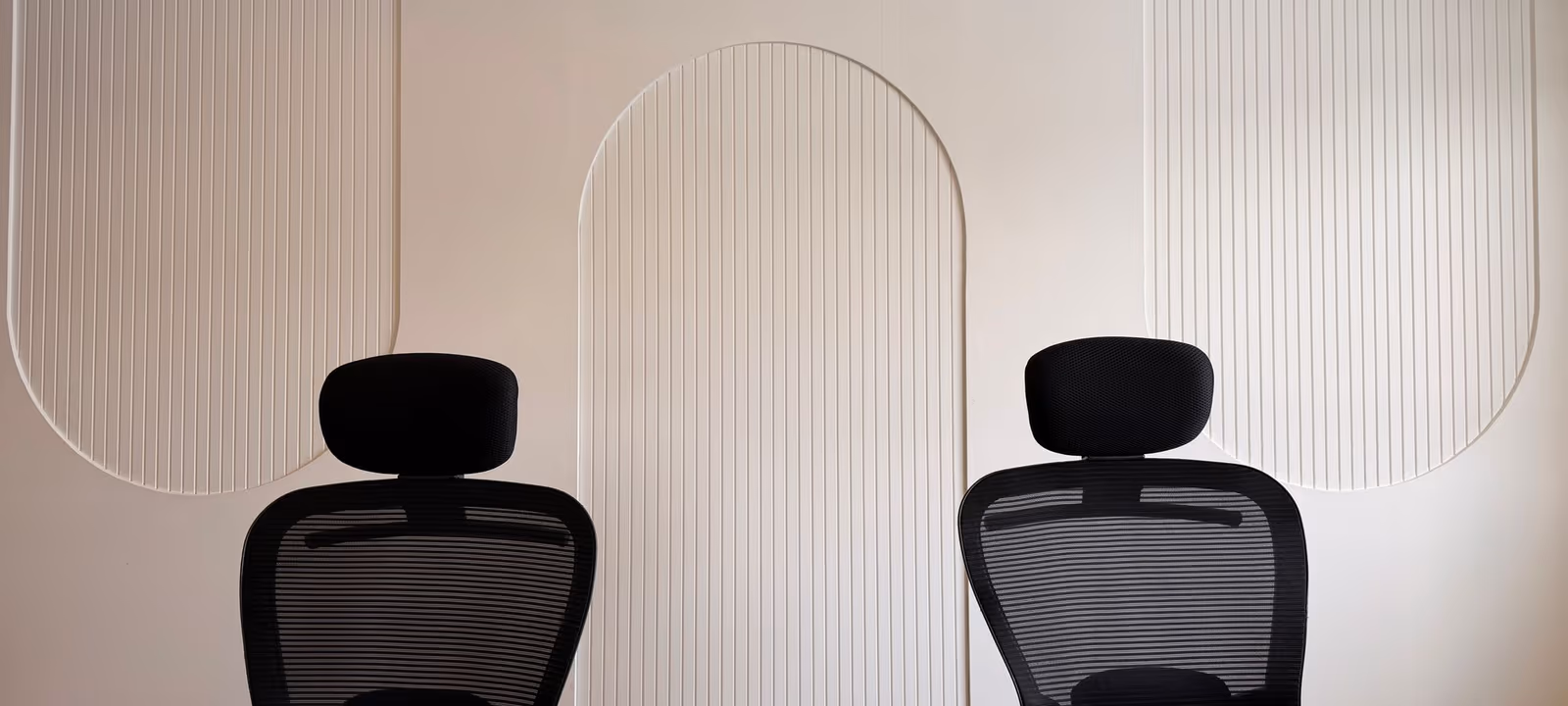 A shared workspace with two chairs at one desk, papers spread across the surface