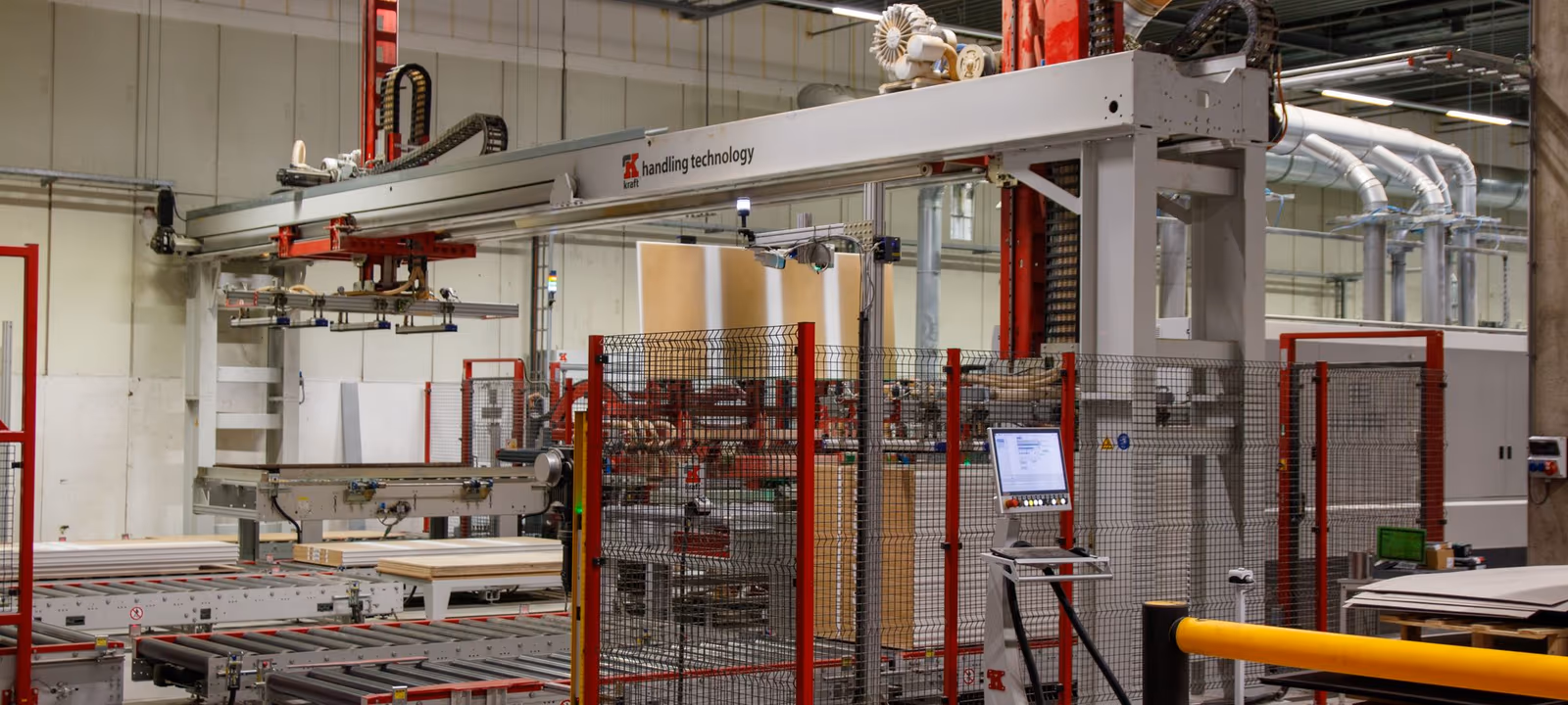 An automotive assembly line with robotic arms poised over a chassis, line receding