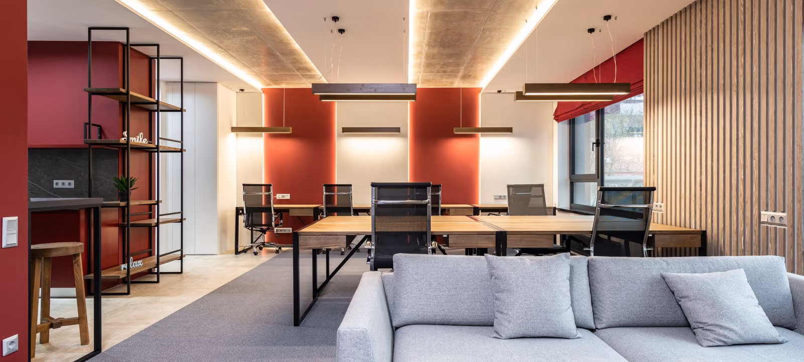 An empty office building lobby with a reception desk and lift doors beyond