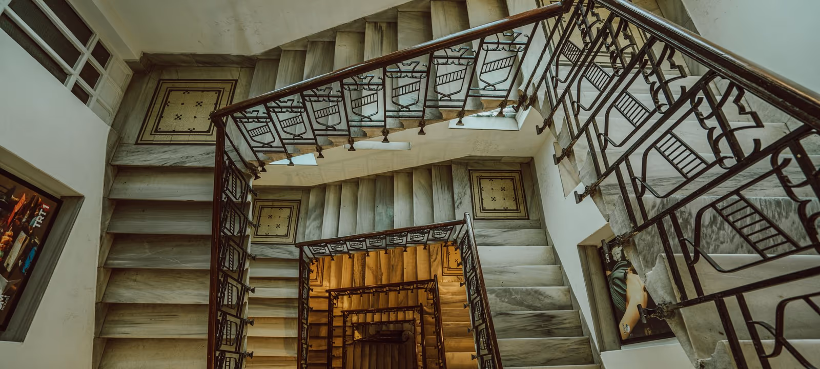 A spiral staircase photographed looking down through several turns to the floor below