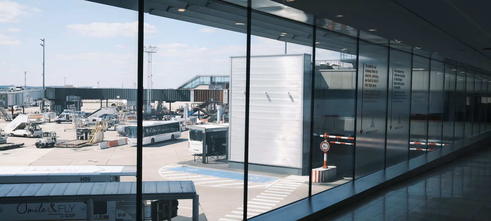 An airport terminal walkway stretching ahead, windows along one side