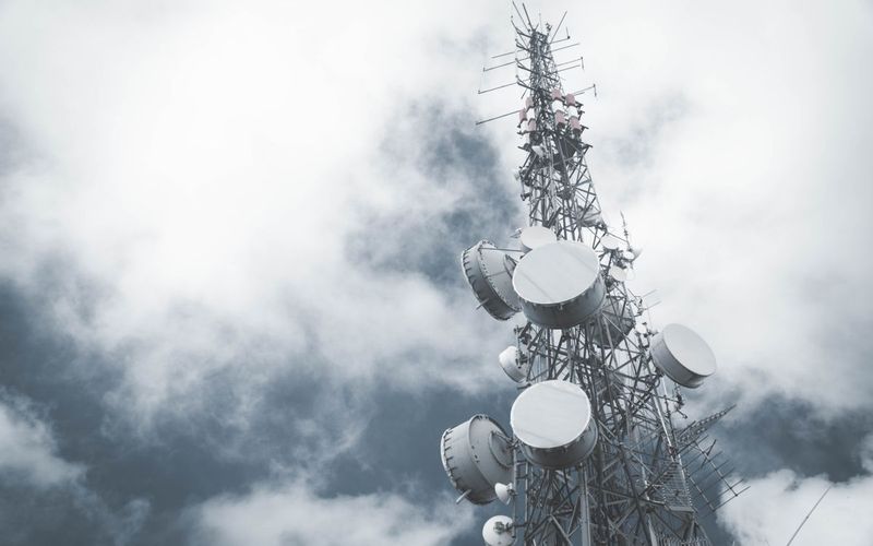 Long term consulting support case study: communication mast with microwave dishes against a cloudy sky