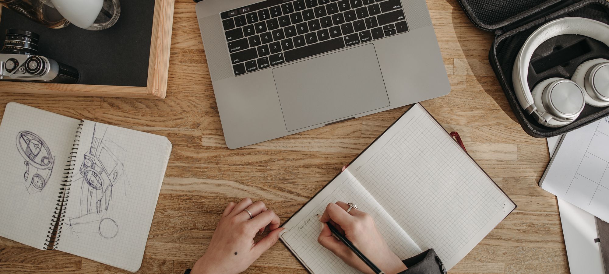 Notes, a laptop and headphones on a desk