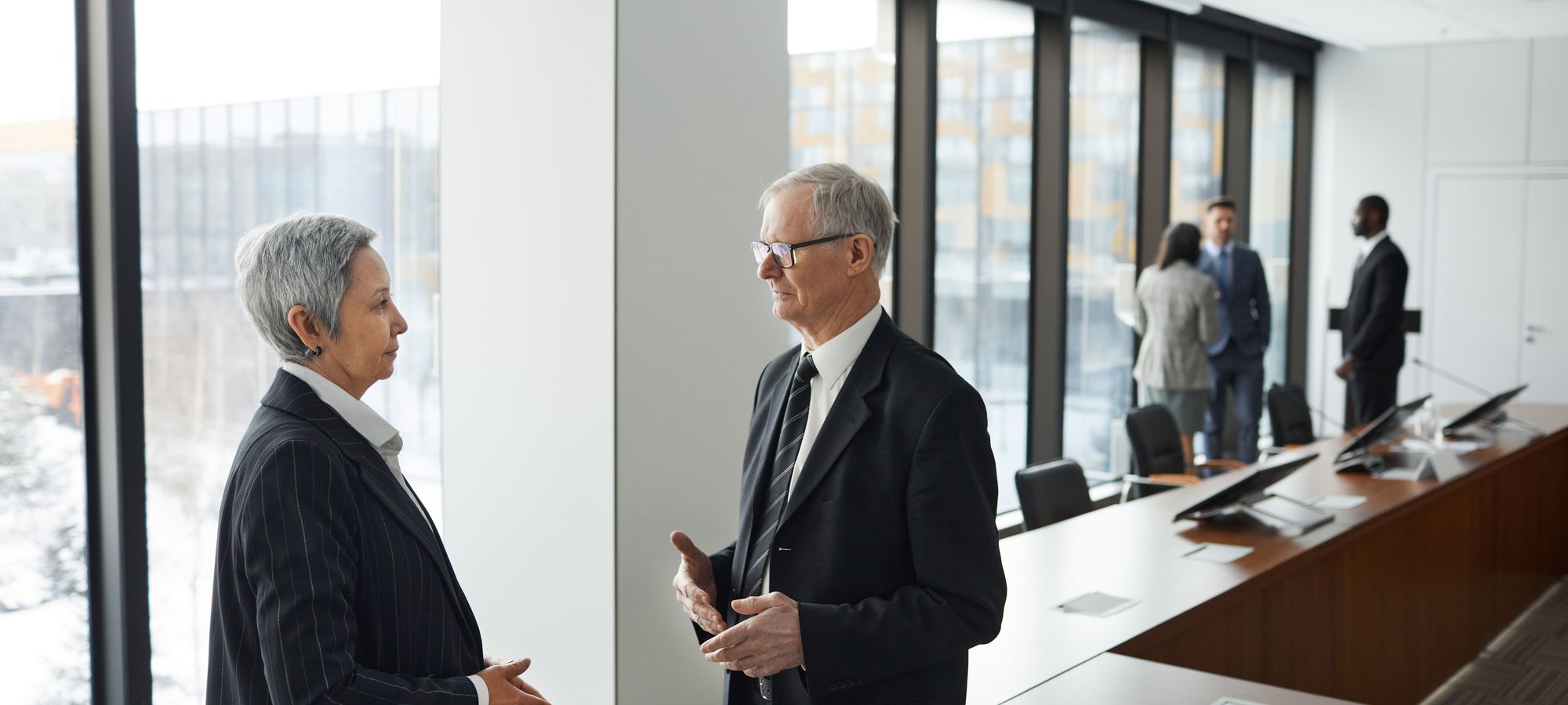 Two colleagues in conversation by an office window