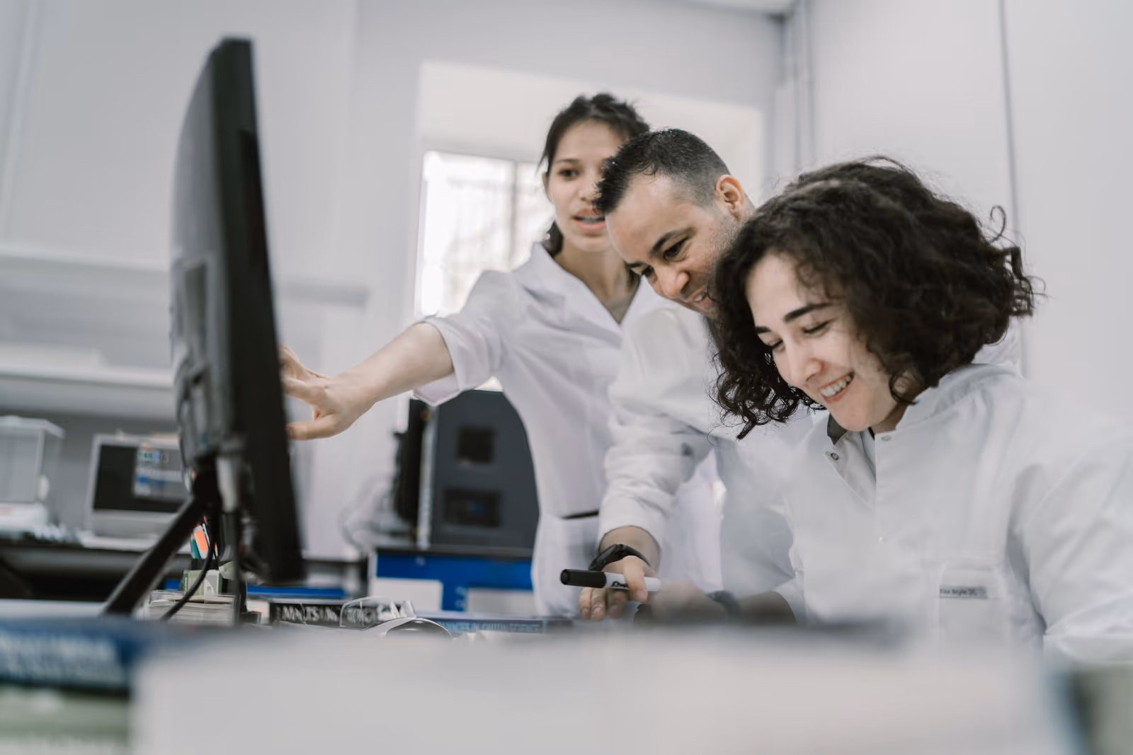 Two scientists smiling at results on a laboratory computer