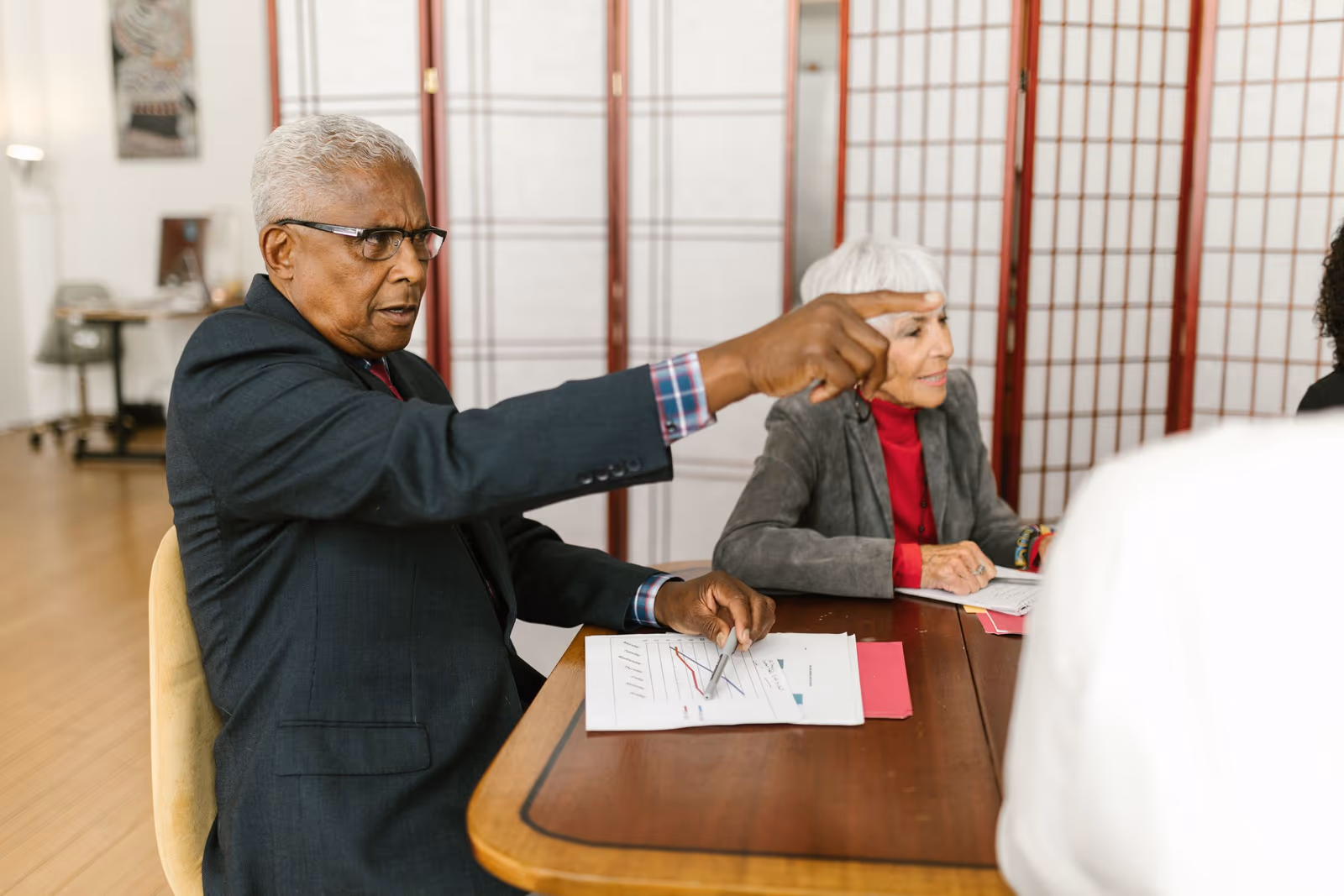 A senior manager presenting figures to a colleague in an office