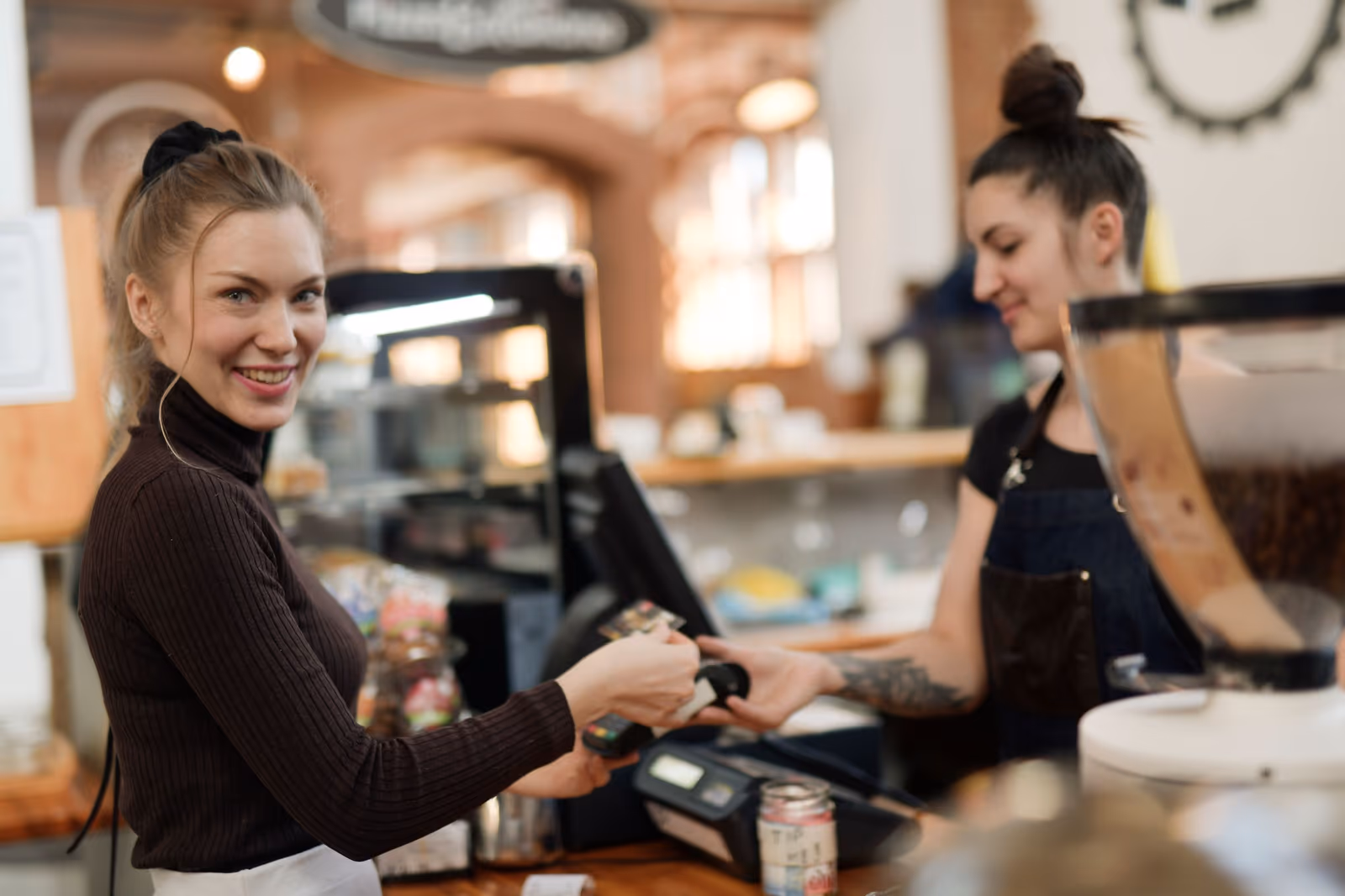 A smiling shop owner serving a customer at the counter