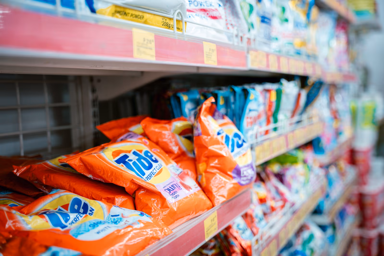 Laundry detergent packs stacked on a supermarket shelf