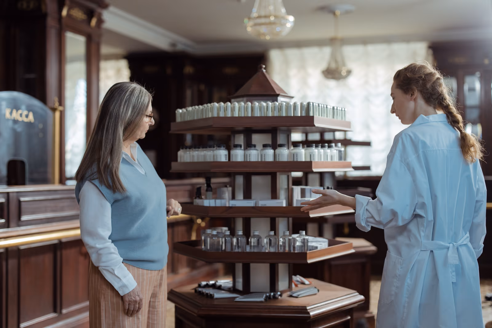 Two pharmacists talking beside stocked pharmacy shelves