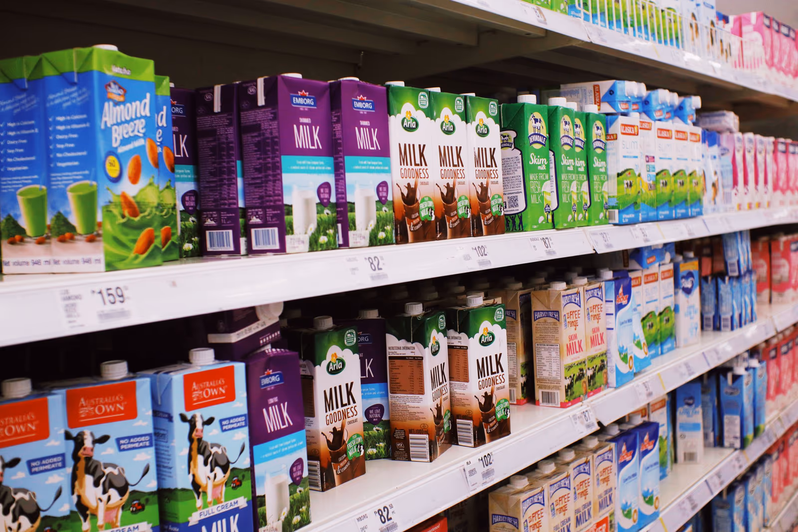 Supermarket shelves stocked with cartons of dairy and juice drinks