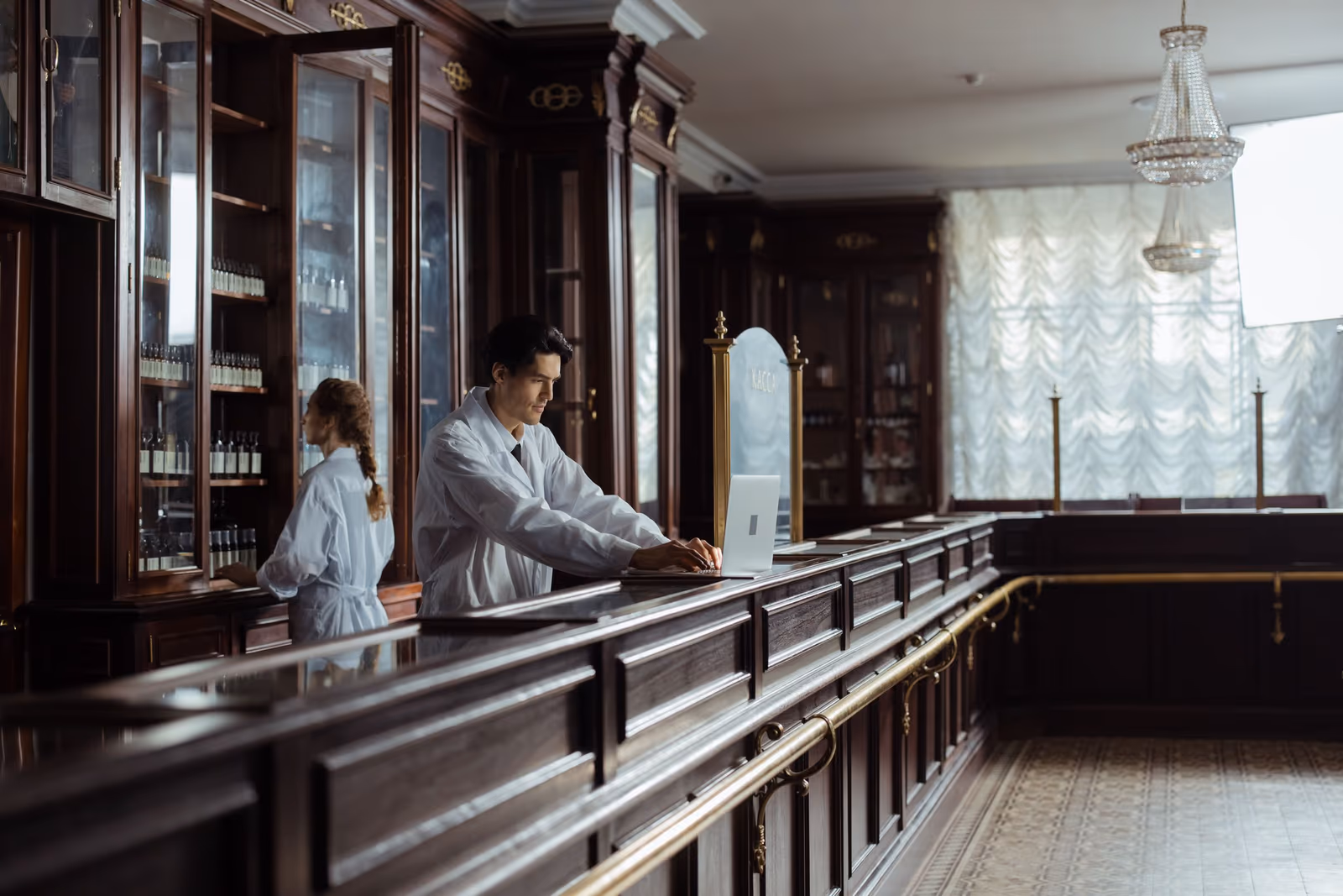 A pharmacist working in a traditional wooden-shelved pharmacy