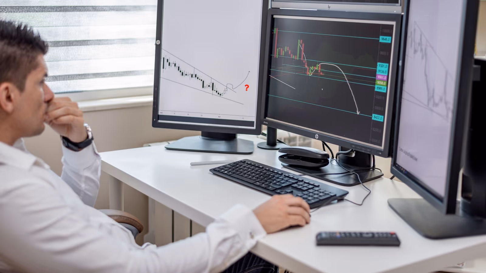 An analyst monitoring transaction charts across several screens