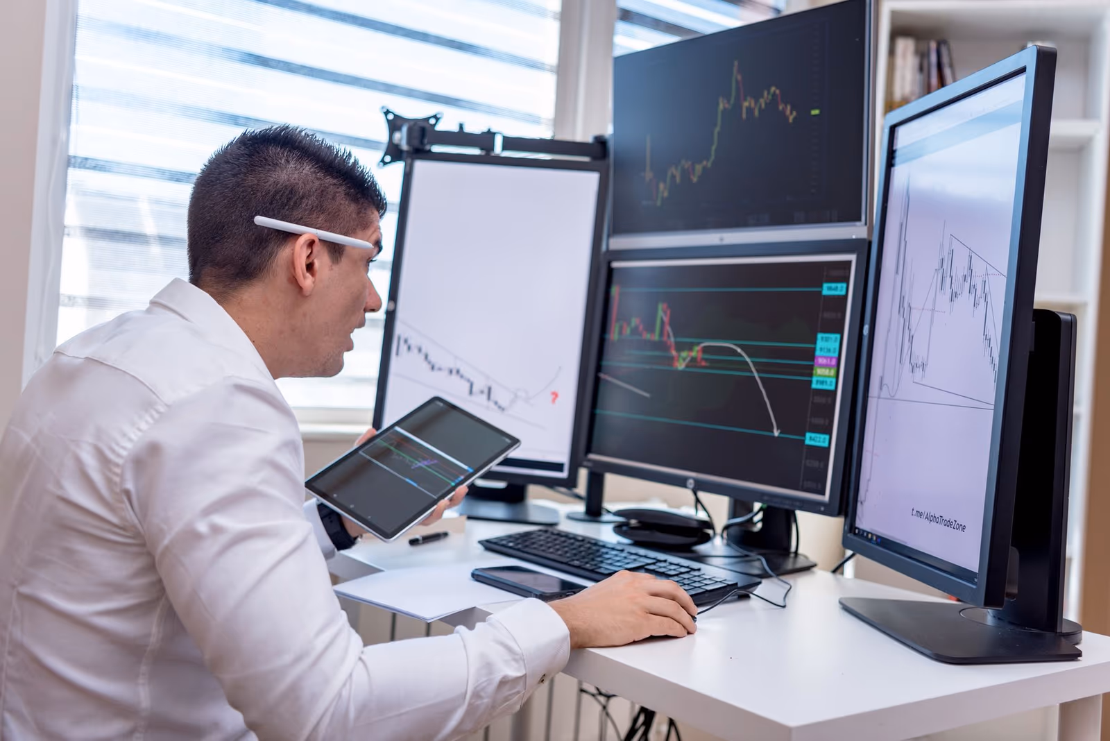 An analyst tracking markets across several screens