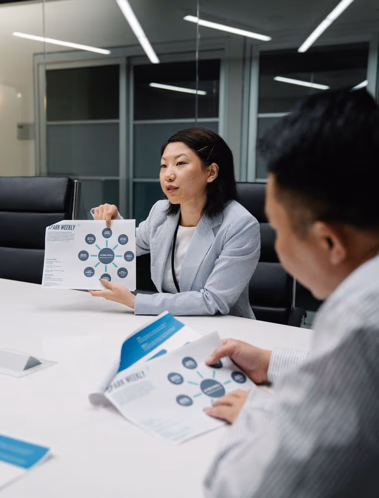 Two sales leaders in discussion by a window