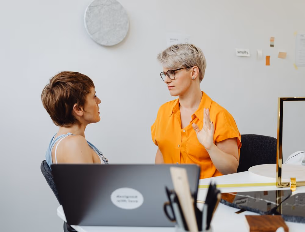Two colleagues comparing notes on a decision